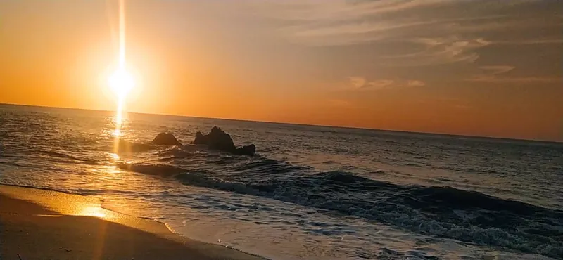 Atardecer con rocas sobre el mar